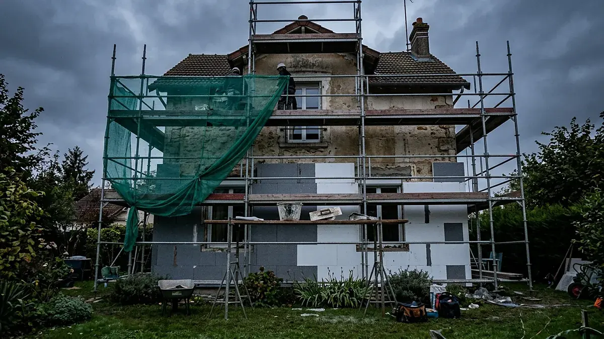 Maison en travaux d'isolation par l'extérieur, entourée d'échafaudages